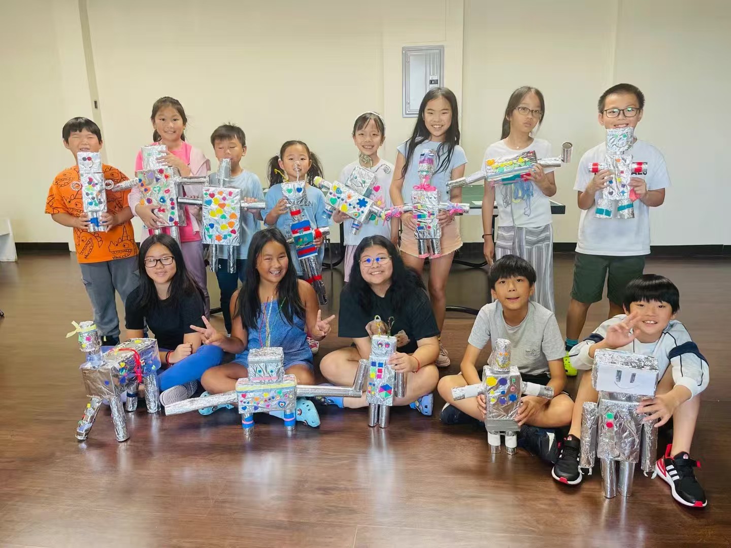 AAA summer campers holding handmade robot projects